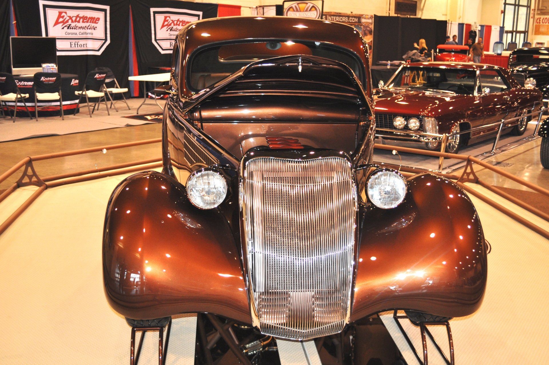 A brown car is on display at a car show