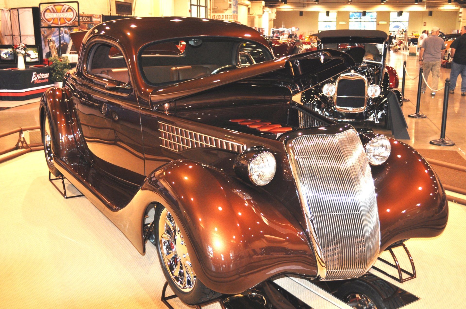 A brown car is on display at a car show