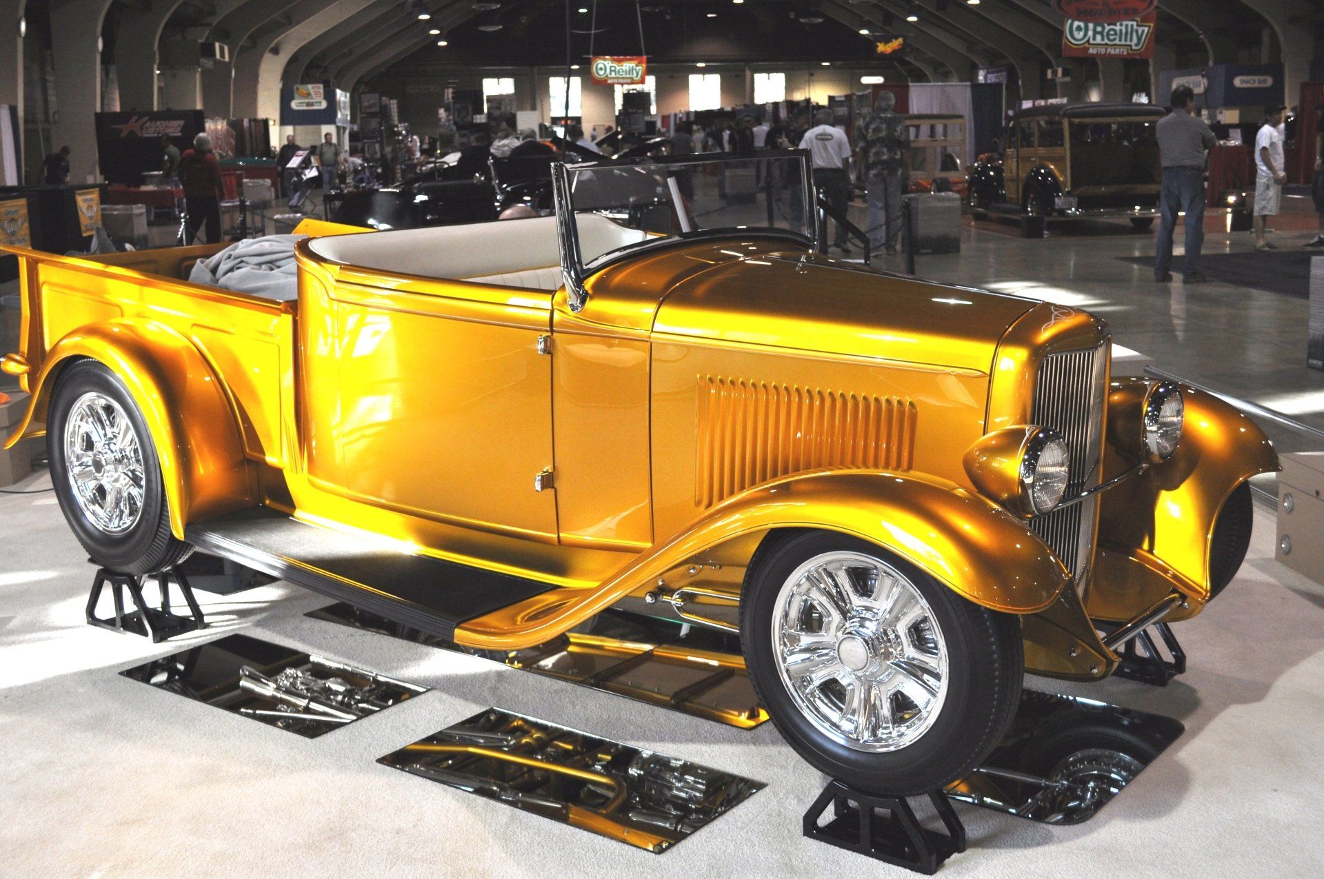 A gold car is on display in a building
