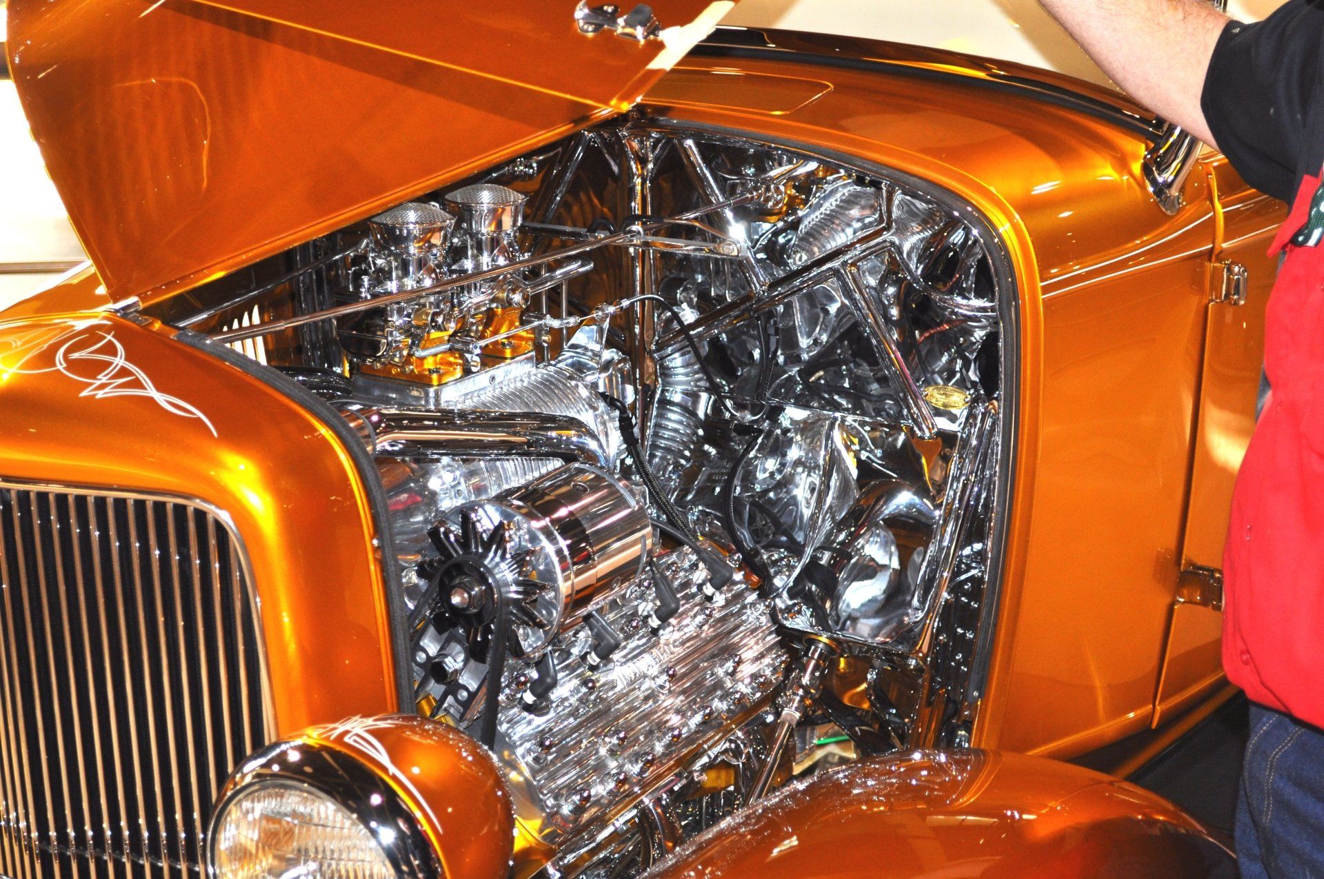 A man is standing next to a car with the hood open
