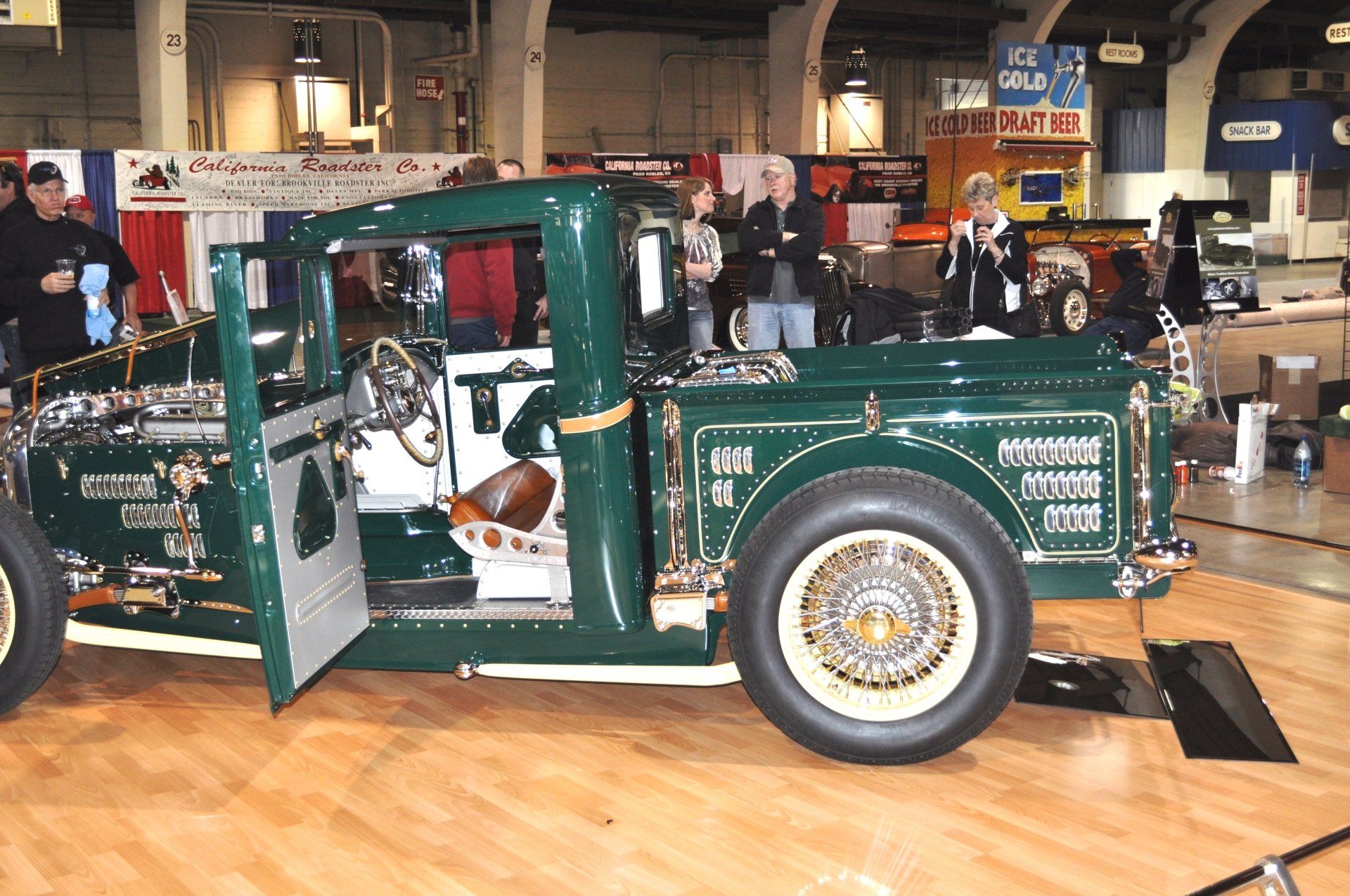 A green truck is on display at a car show