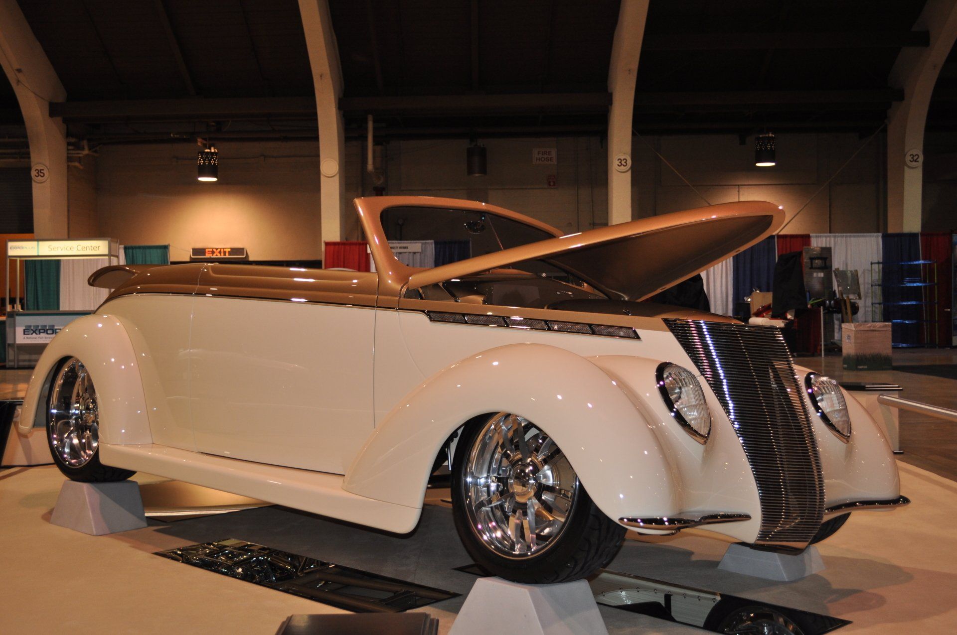 A white car with the hood open is on display