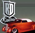 A red car is parked in front of a logo for rd kustoms.