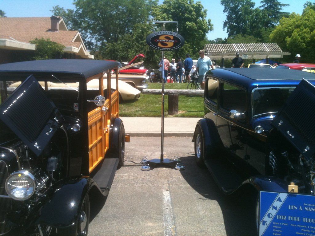 Two old cars are parked next to each other in a parking lot