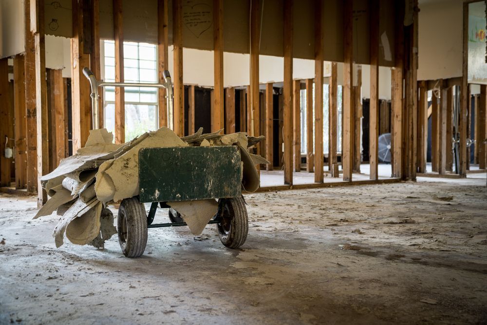 A wheelbarrow is sitting in the middle of a building under construction.