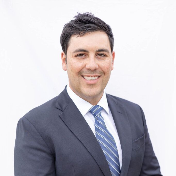 A man in a suit and tie is smiling for the camera.