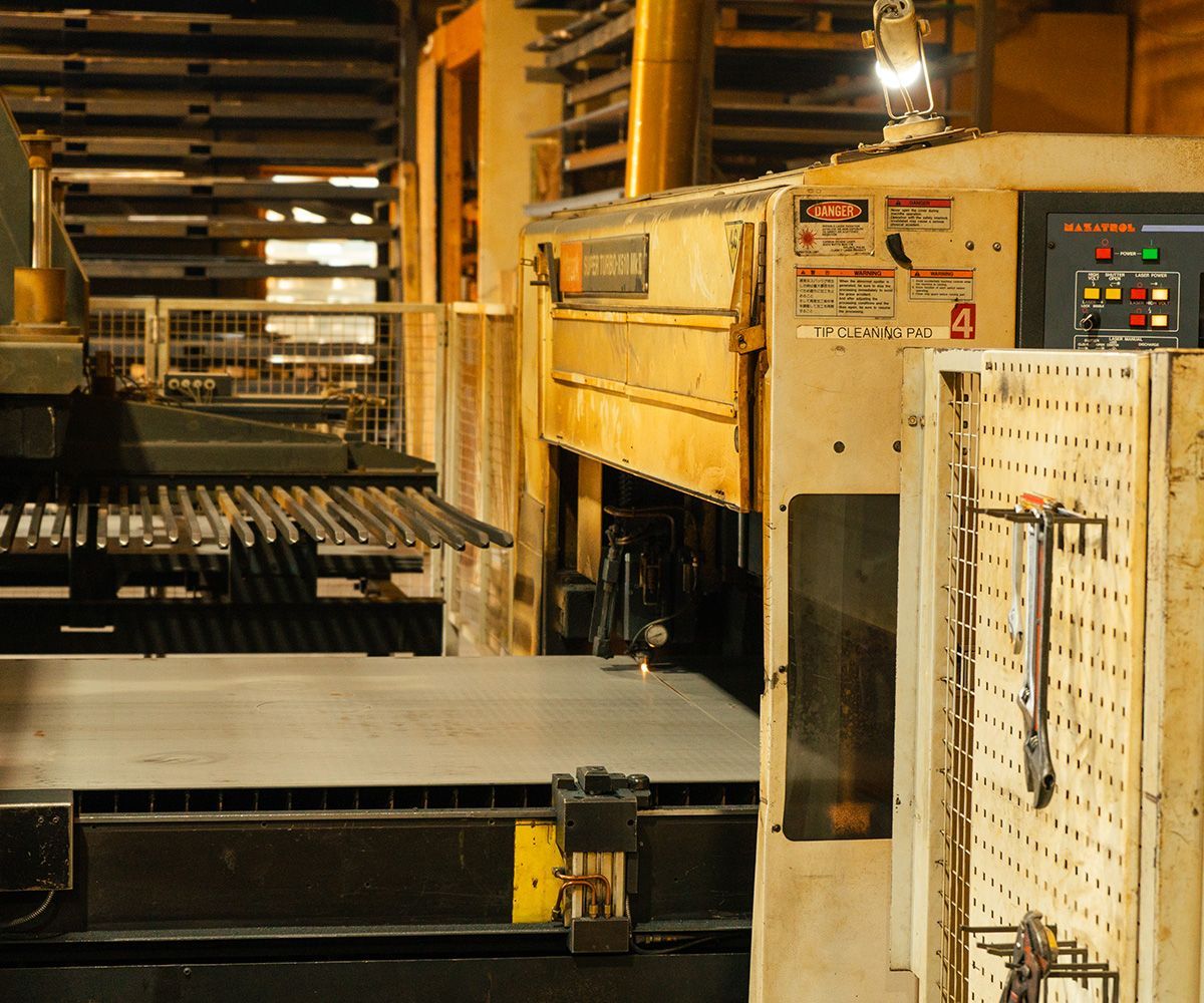 Large industrial machine in a factory setting, possibly for metalworking. Yellow and grey colors are prominent.