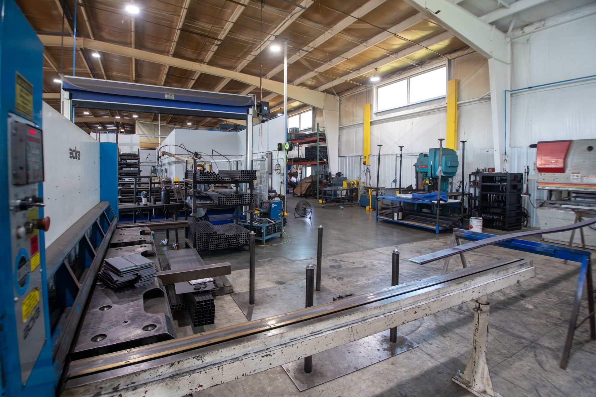 Metalworking shop interior with various machinery and equipment.