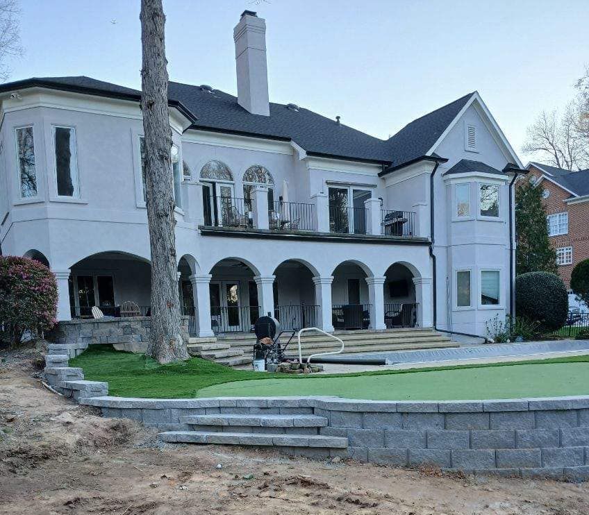 A large white house with a green lawn in front of it.