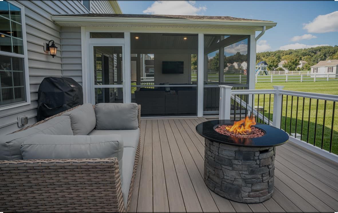 A screened in porch with a fire pit and a couch.