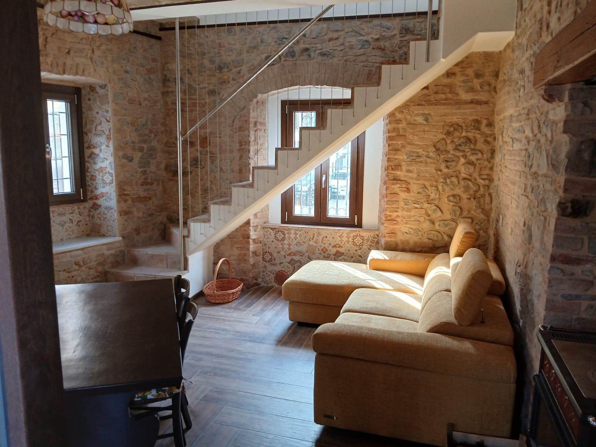 Tre campioni di persiane, nei colori bianco, verde e marrone, esposti su una parete grigia accanto a una porta di legno chiara.