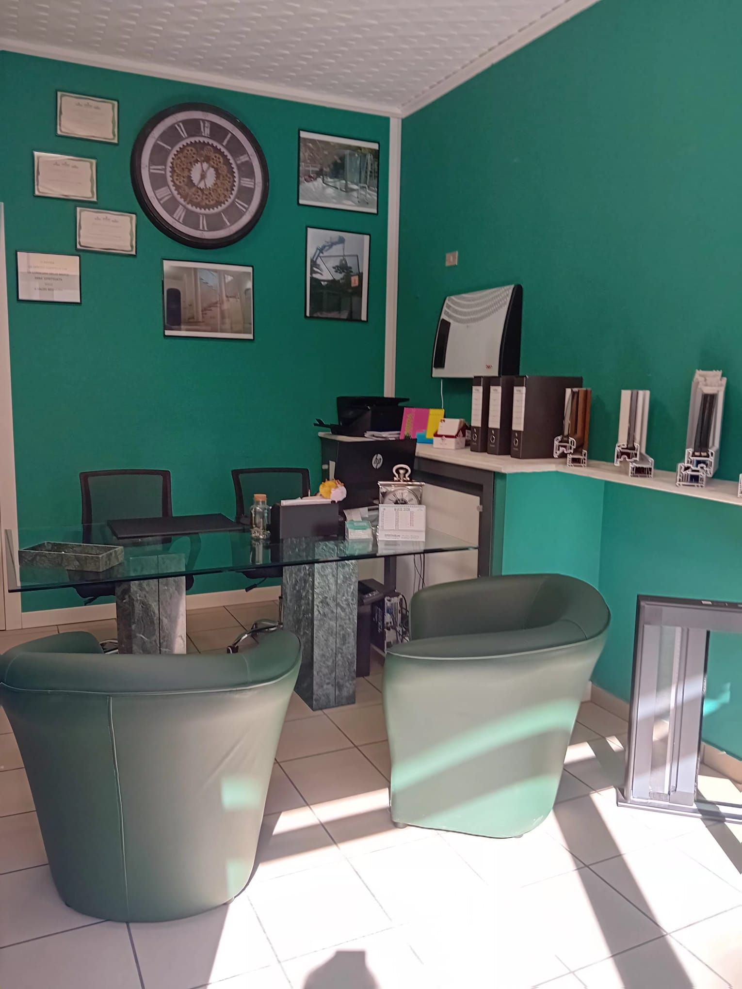 Una stanza vuota con pavimento in legno, pareti inclinate, ampi lucernari e una porta aperta che conduce a un bagno moderno.