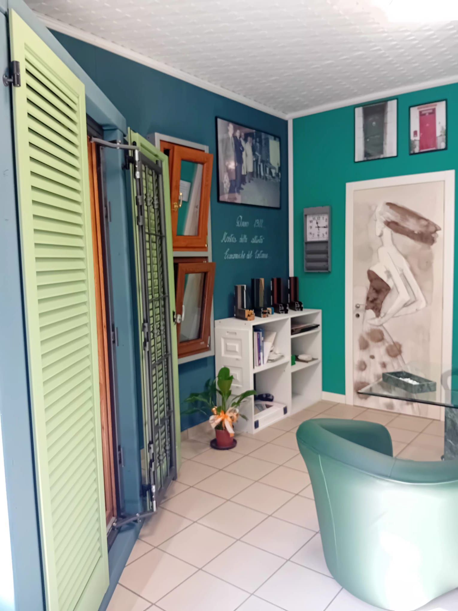 Un moderno interno d'ufficio con scrivania e sedie, vetrine bianche e un'insegna su una parete grigio scuro.