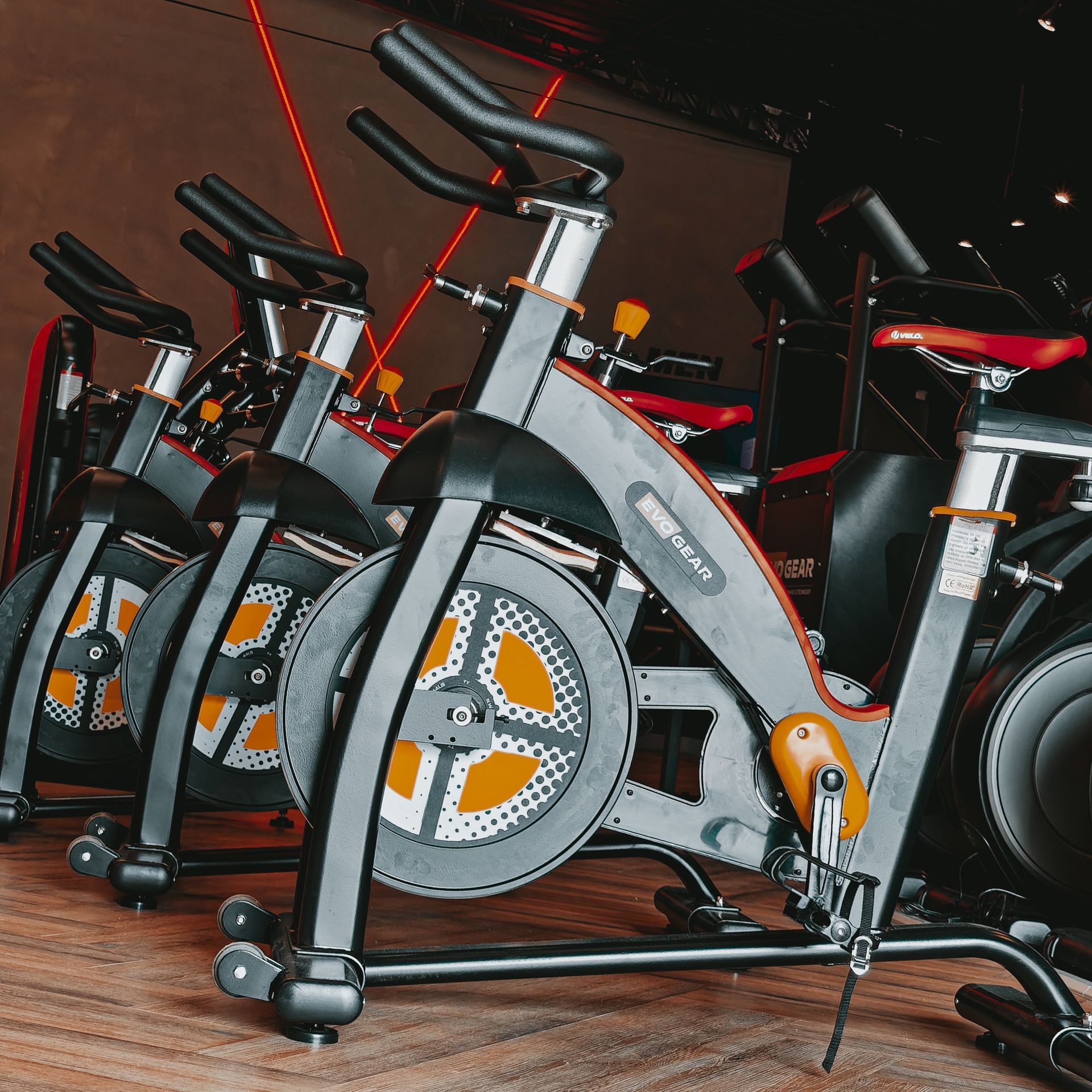 A row of exercise bikes are lined up in a gym.