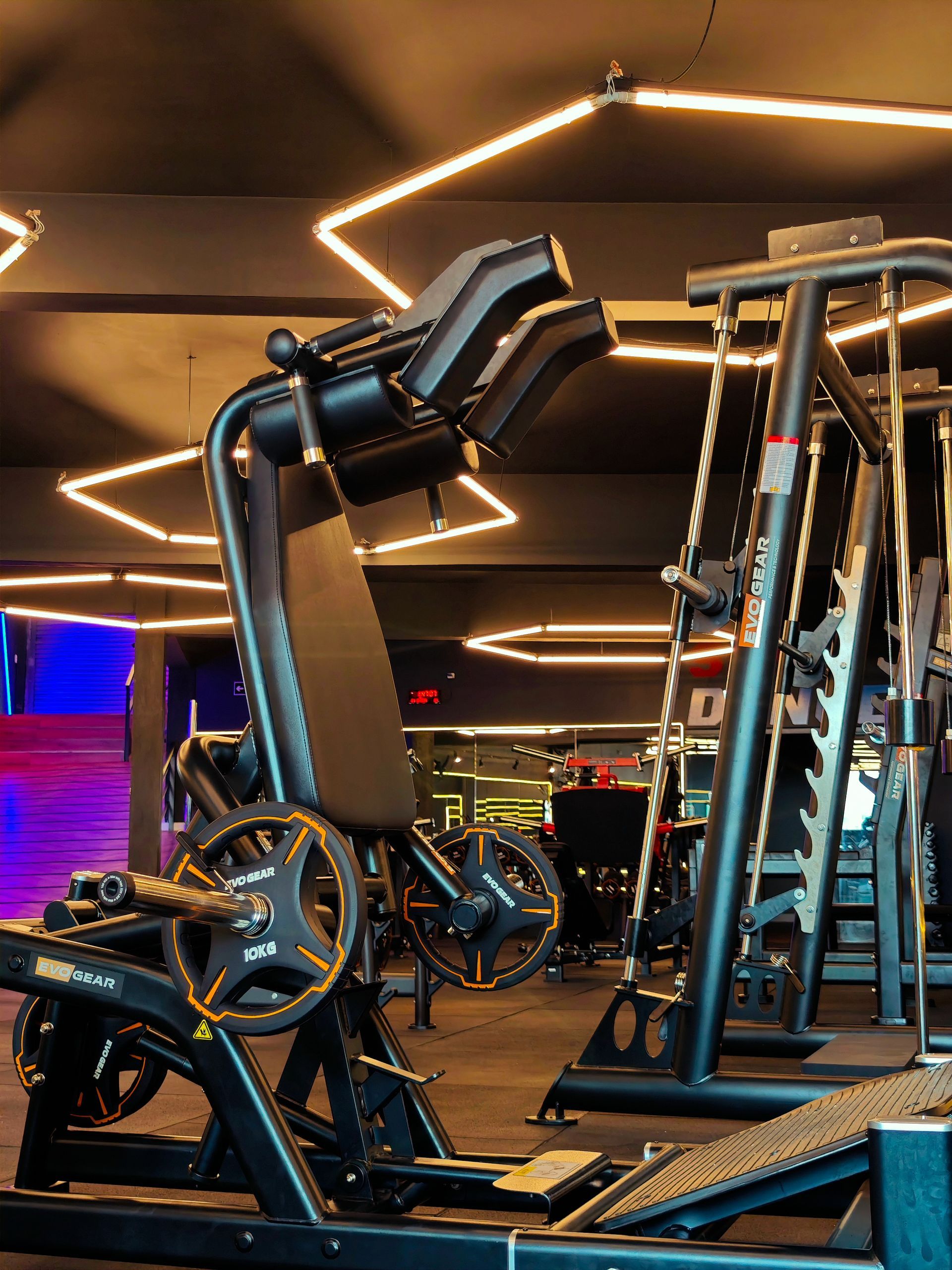 One gym with lots of exercise equipment and overhead lights.