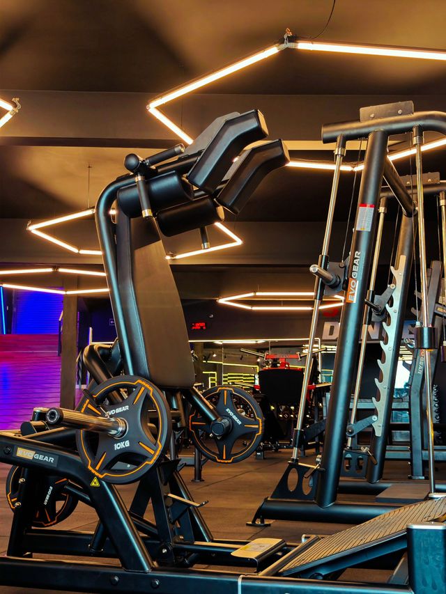One gym with lots of exercise equipment and overhead lights.