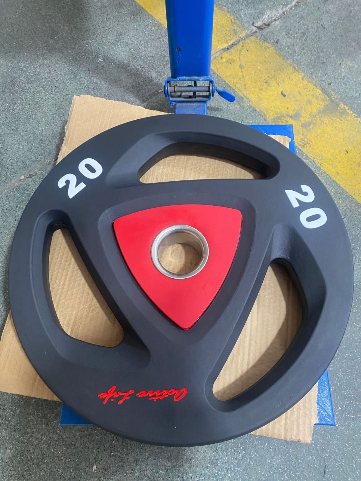A black and red weight plate with the number 20