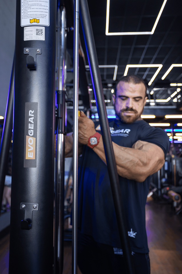 Um homem está se exercitando em uma máquina em uma academia.