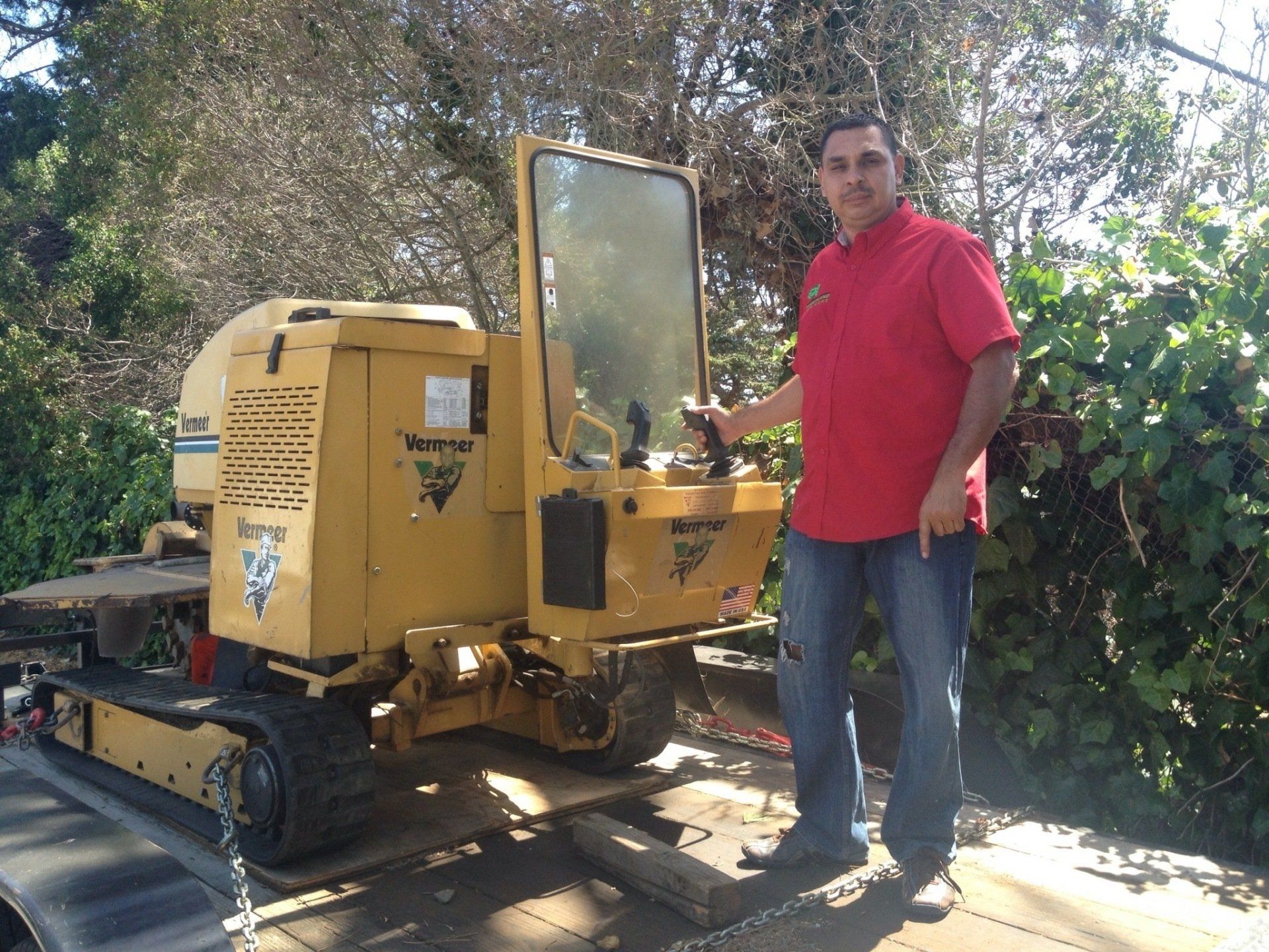 Albert Briseno -Timberland Tree Care Owner standing with his stump grinder equipment