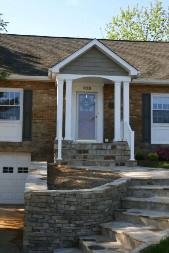 A brick house with a porch and steps leading up to it