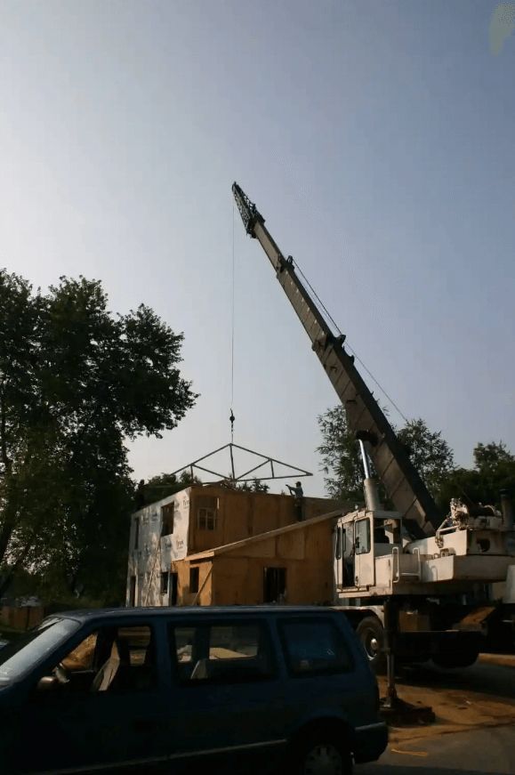 A car is parked in front of a building under construction