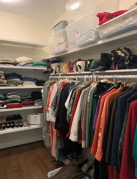 A walk in closet filled with lots of clothes and shoes.