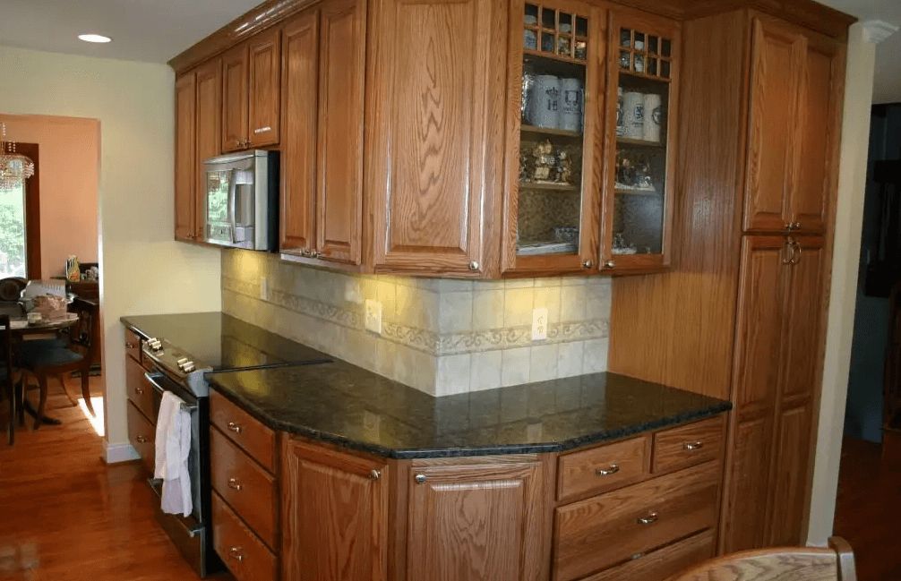 A kitchen with wooden cabinets and black granite counter tops