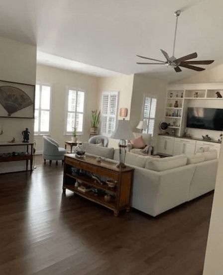 A living room with a white couch and a ceiling fan