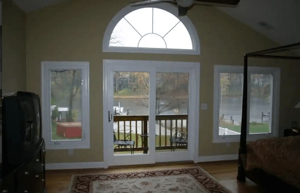 A bedroom with a canopy bed and sliding glass doors