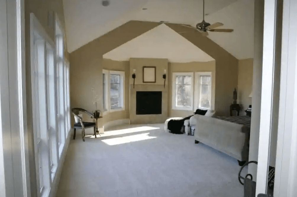 A living room with a vaulted ceiling and a fireplace