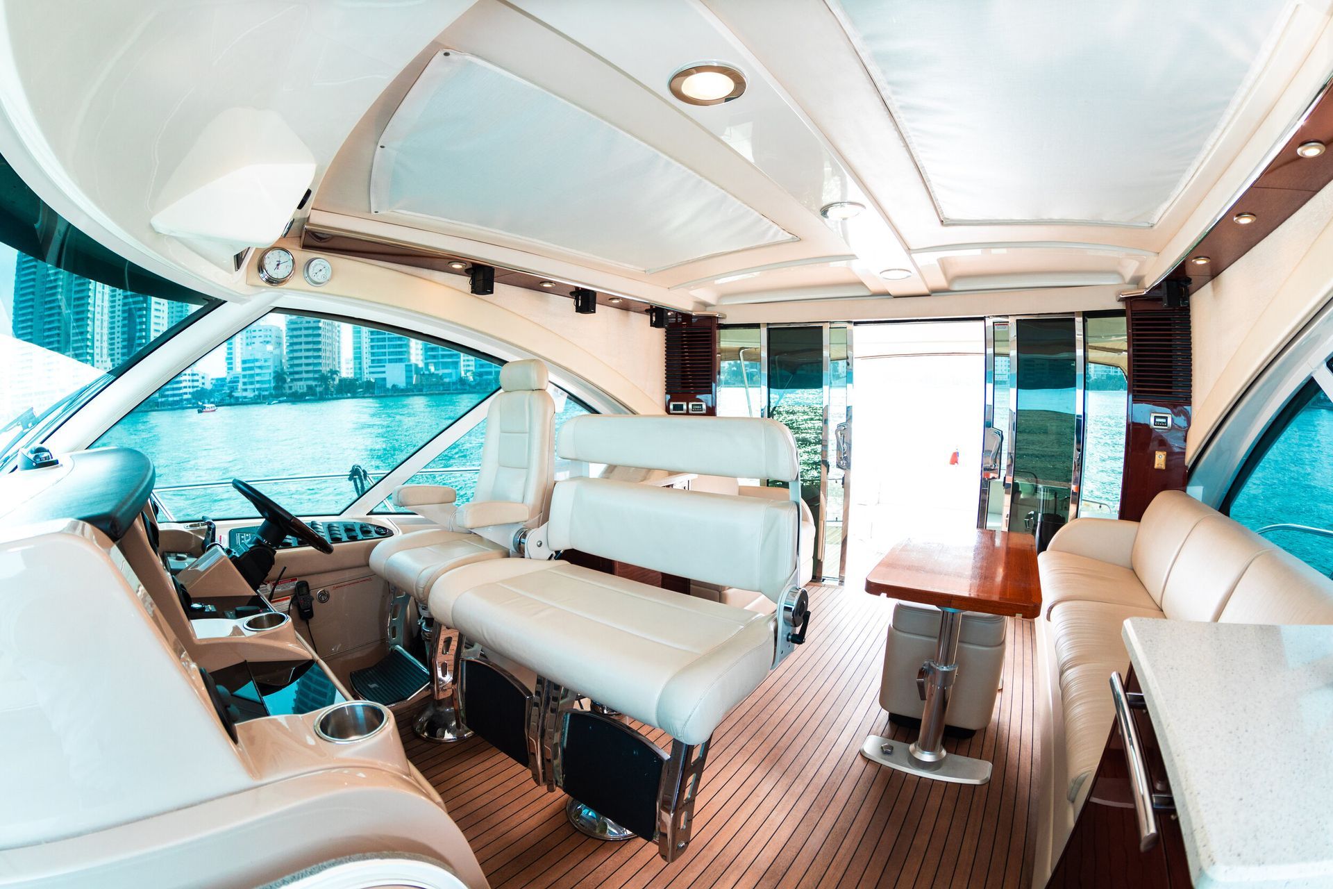 The interior of a yacht with a steering wheel and a table.
