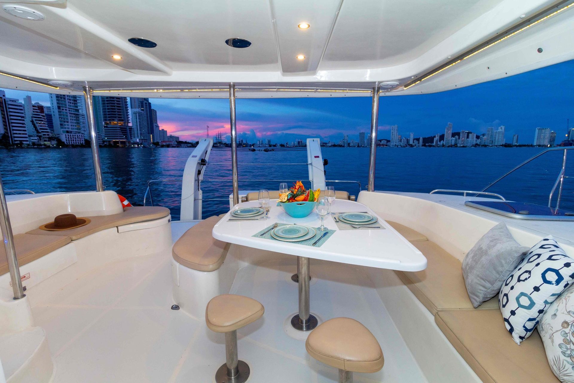 There is a table and chairs on the deck of a boat.