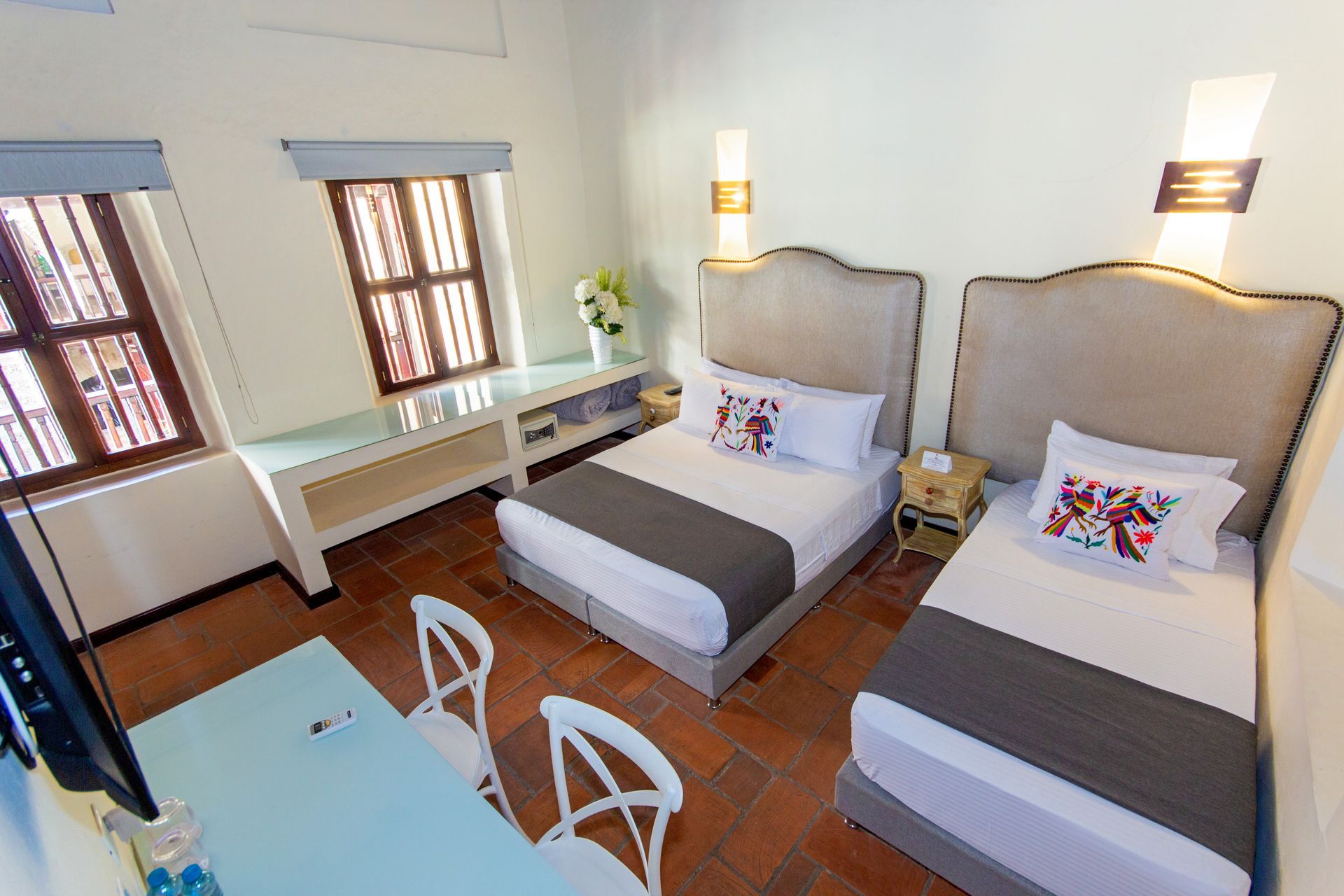 A hotel room with two beds , a desk and a television.