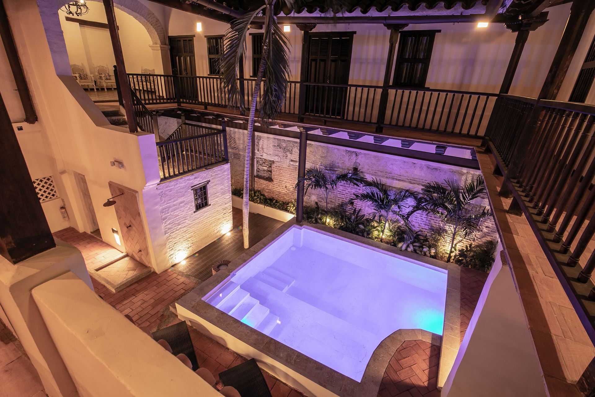 An aerial view of a swimming pool in the middle of a courtyard.