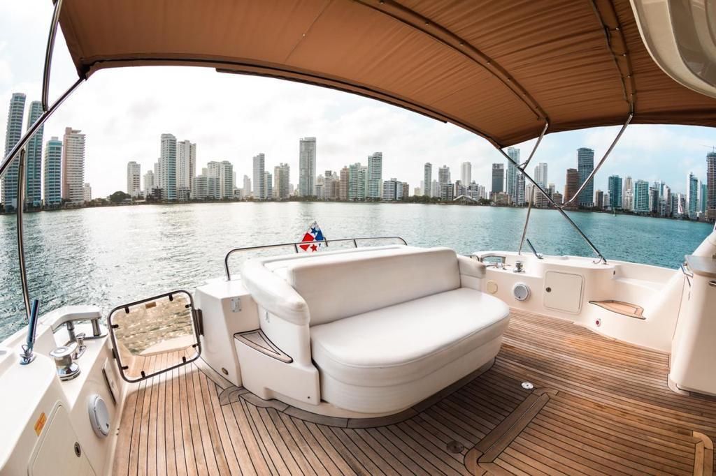 A couch on the deck of a boat with a city skyline in the background