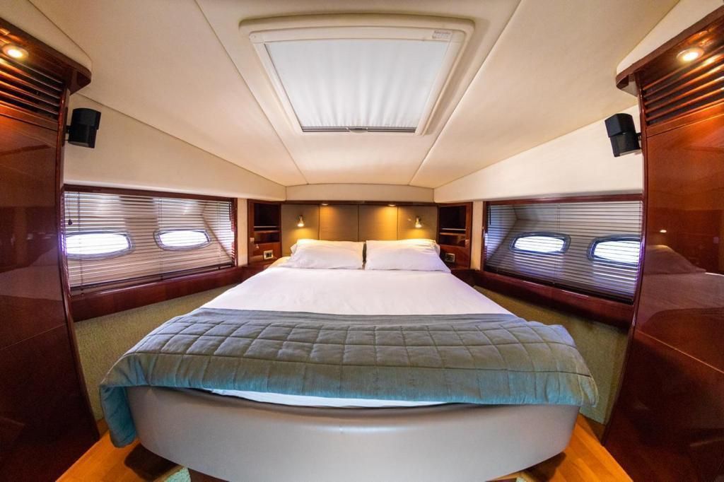 There is a large bed in the middle of the room on the boat.