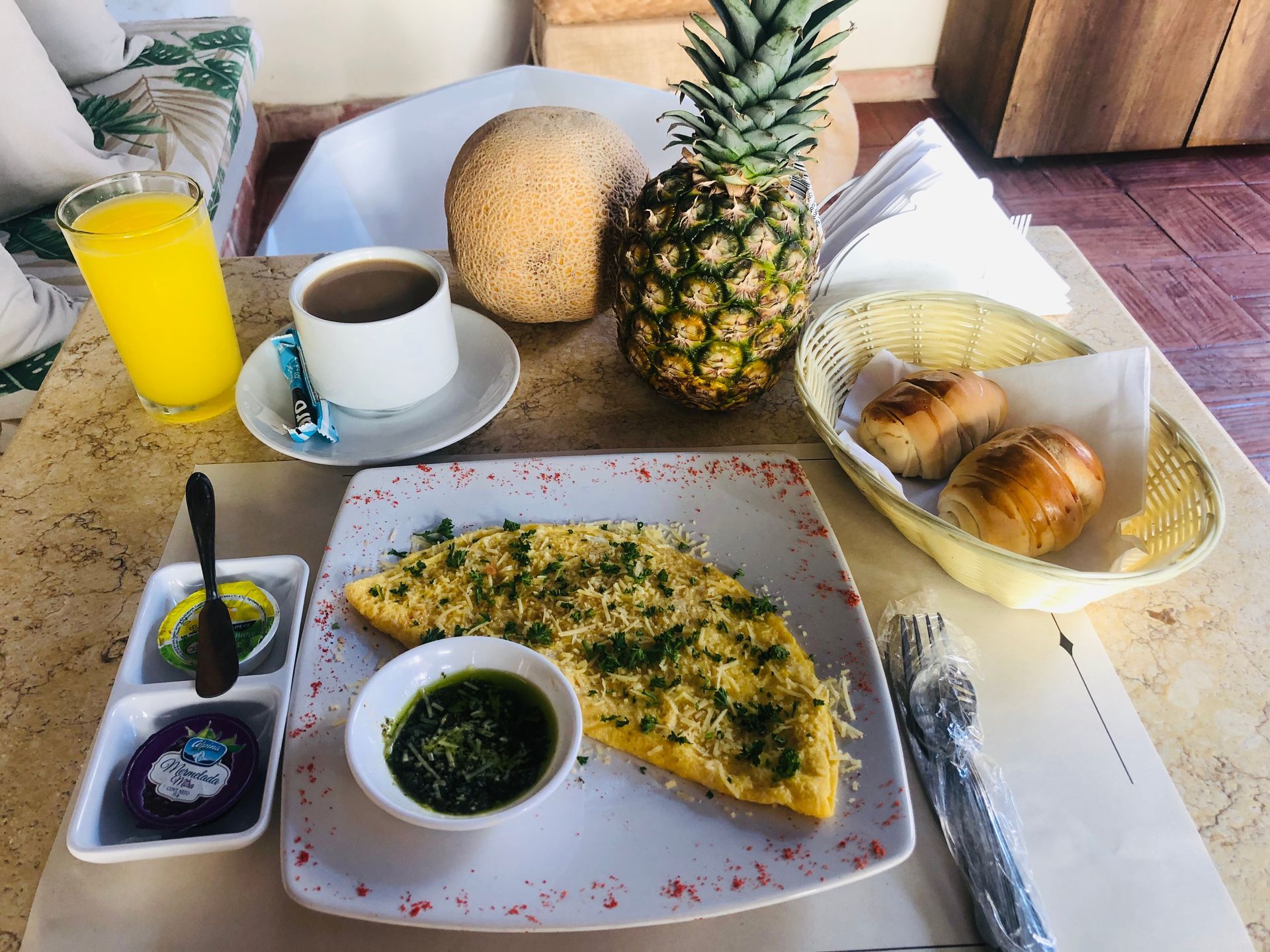 A table topped with a plate of food and a pineapple.