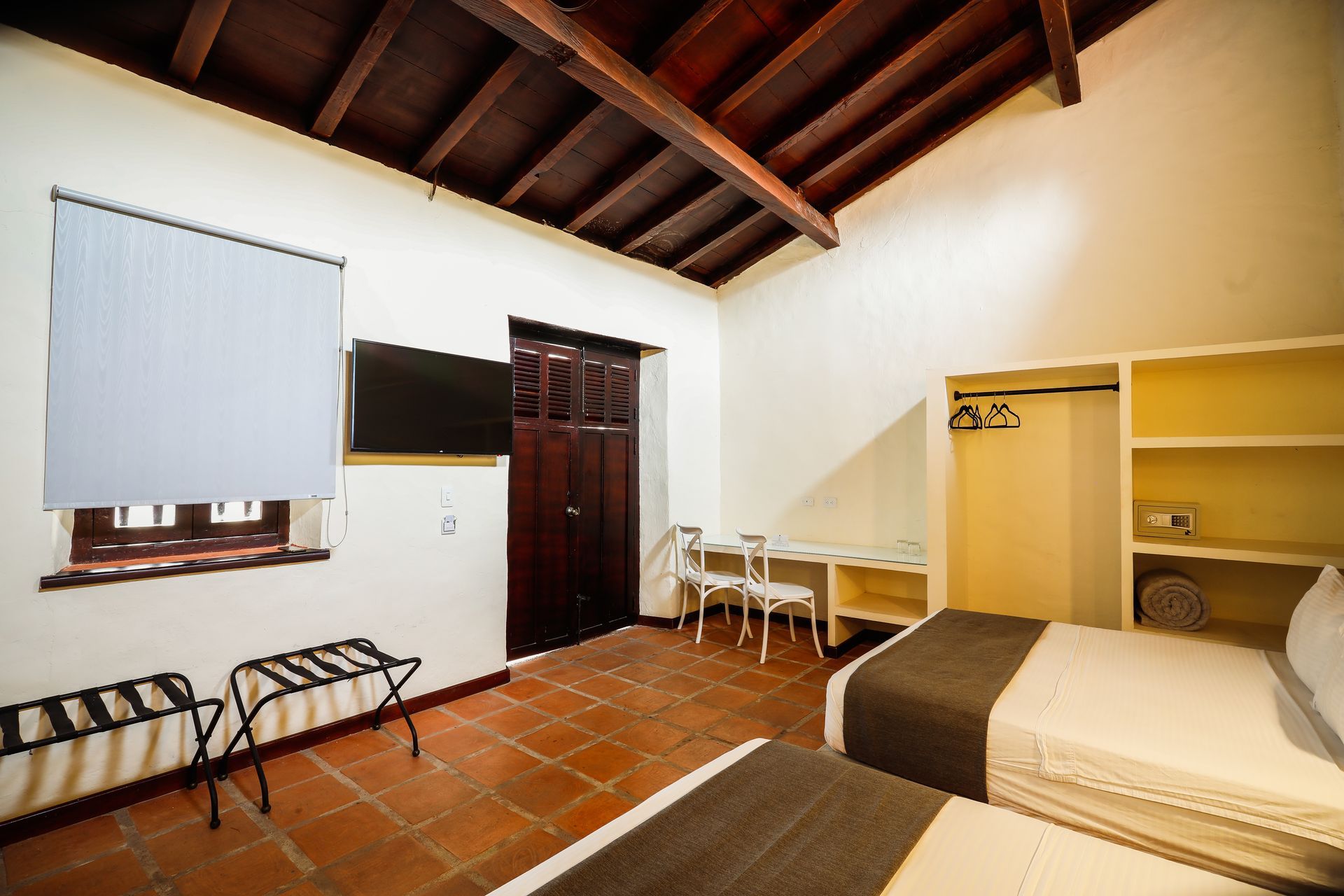 A hotel room with two beds , a desk and a television.