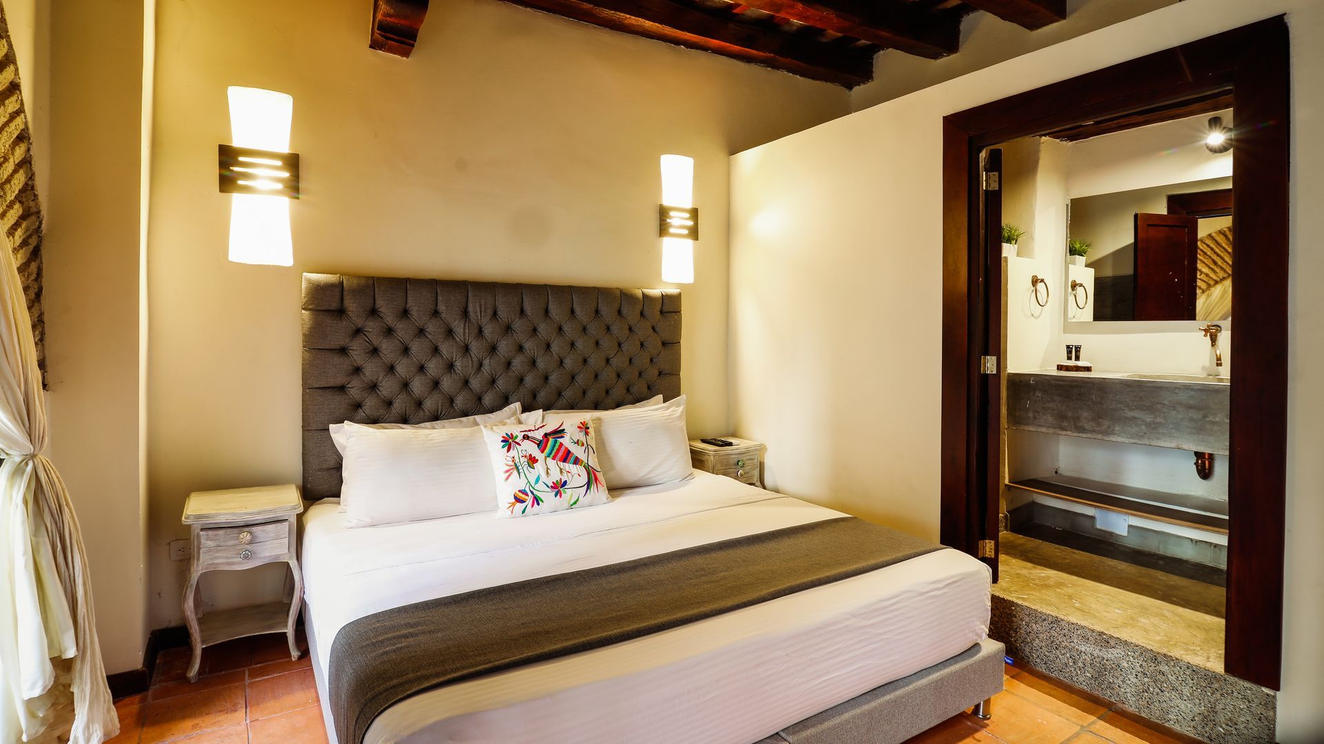 A hotel room with a king size bed and a bathroom.