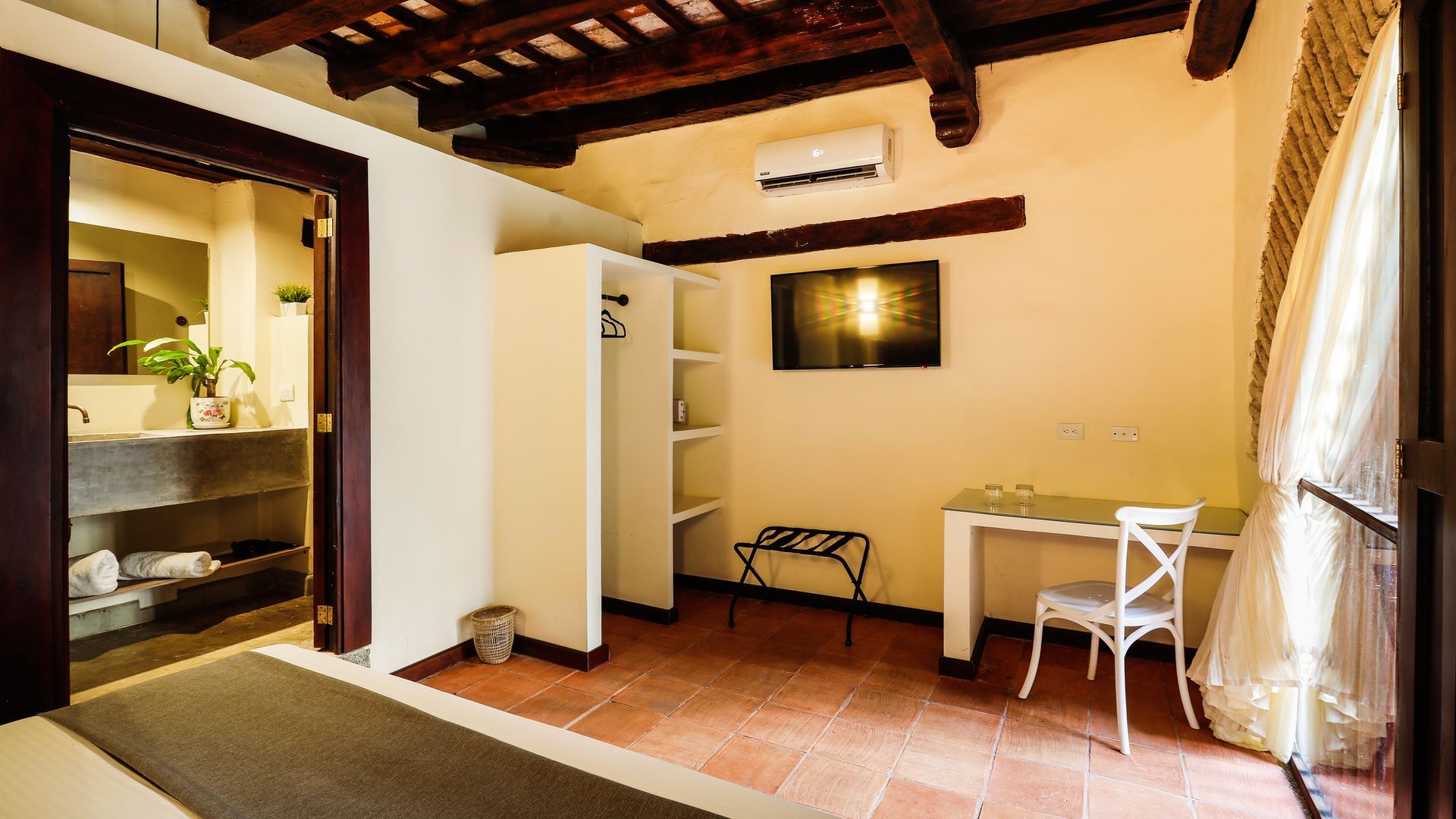A bedroom with a bed , desk , chair and television.