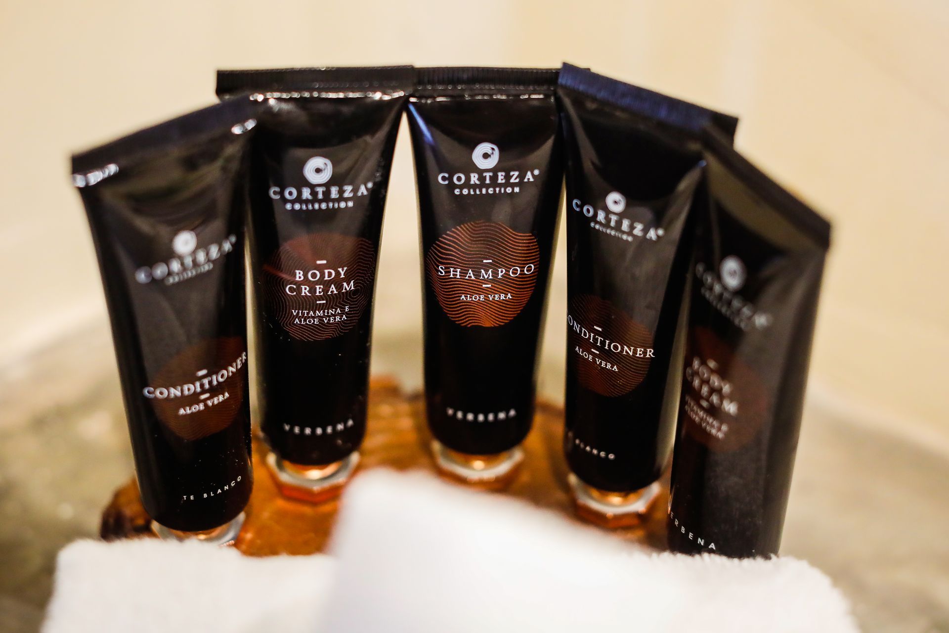 A bunch of bottles of lotion are sitting on top of a towel.