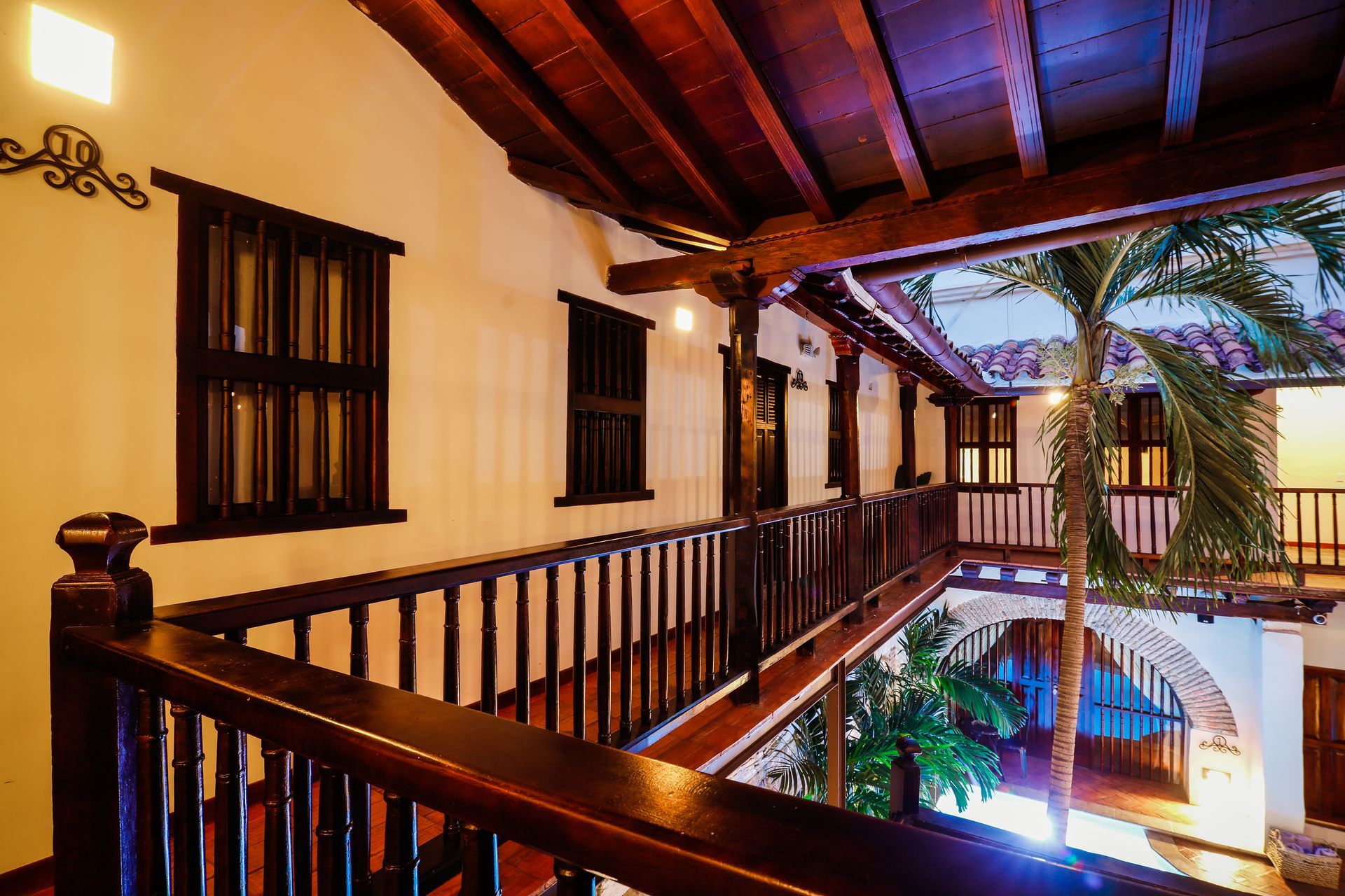 A balcony with a wooden railing and a palm tree