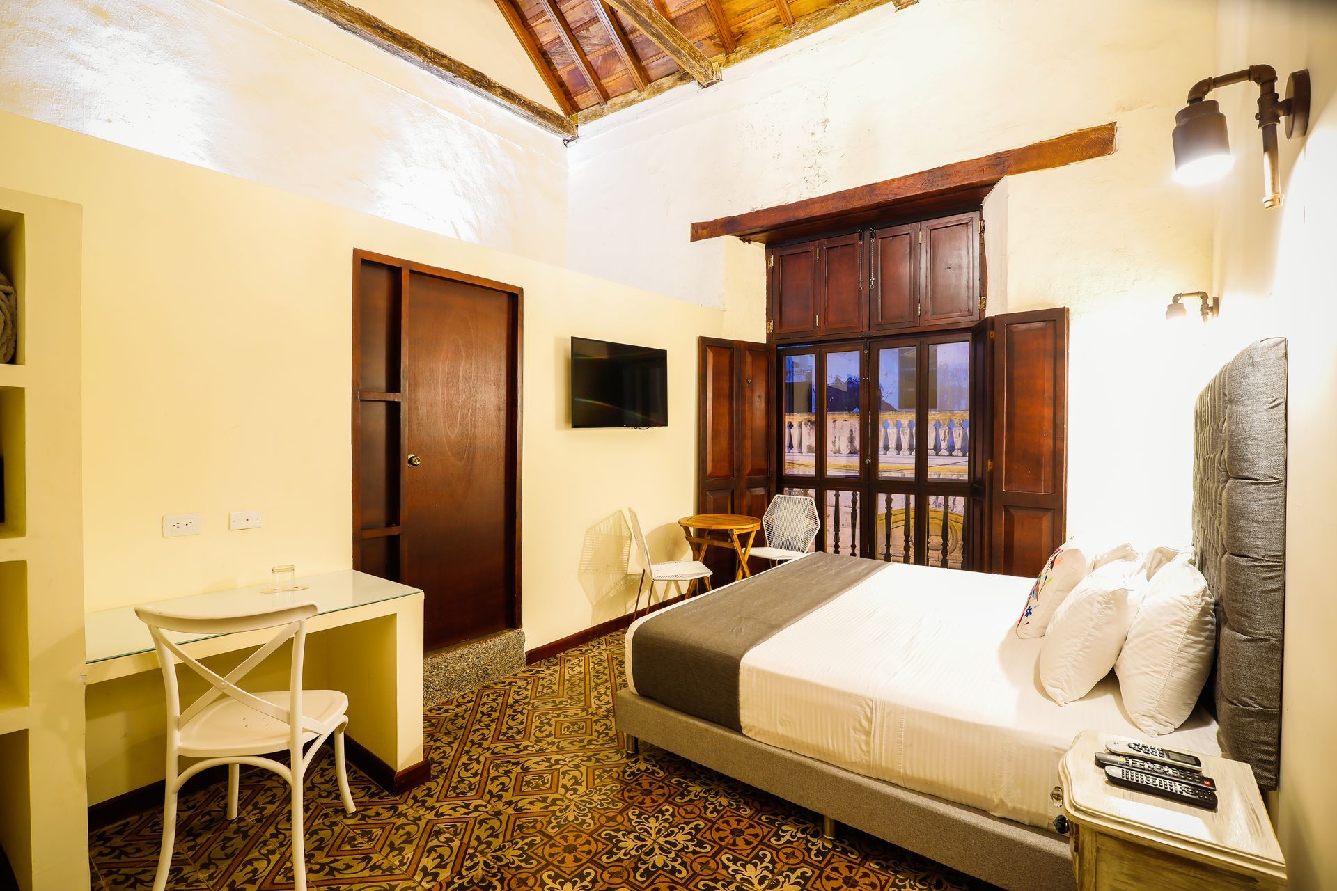 A hotel room with a large bed , desk , chair and television.