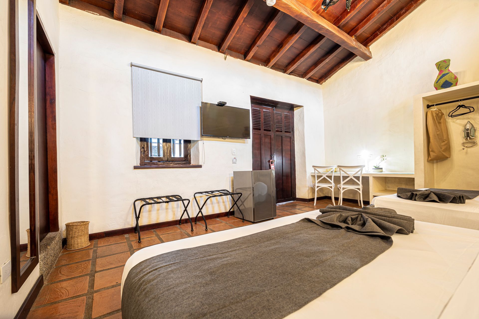 A hotel room with two beds , a desk and a television.