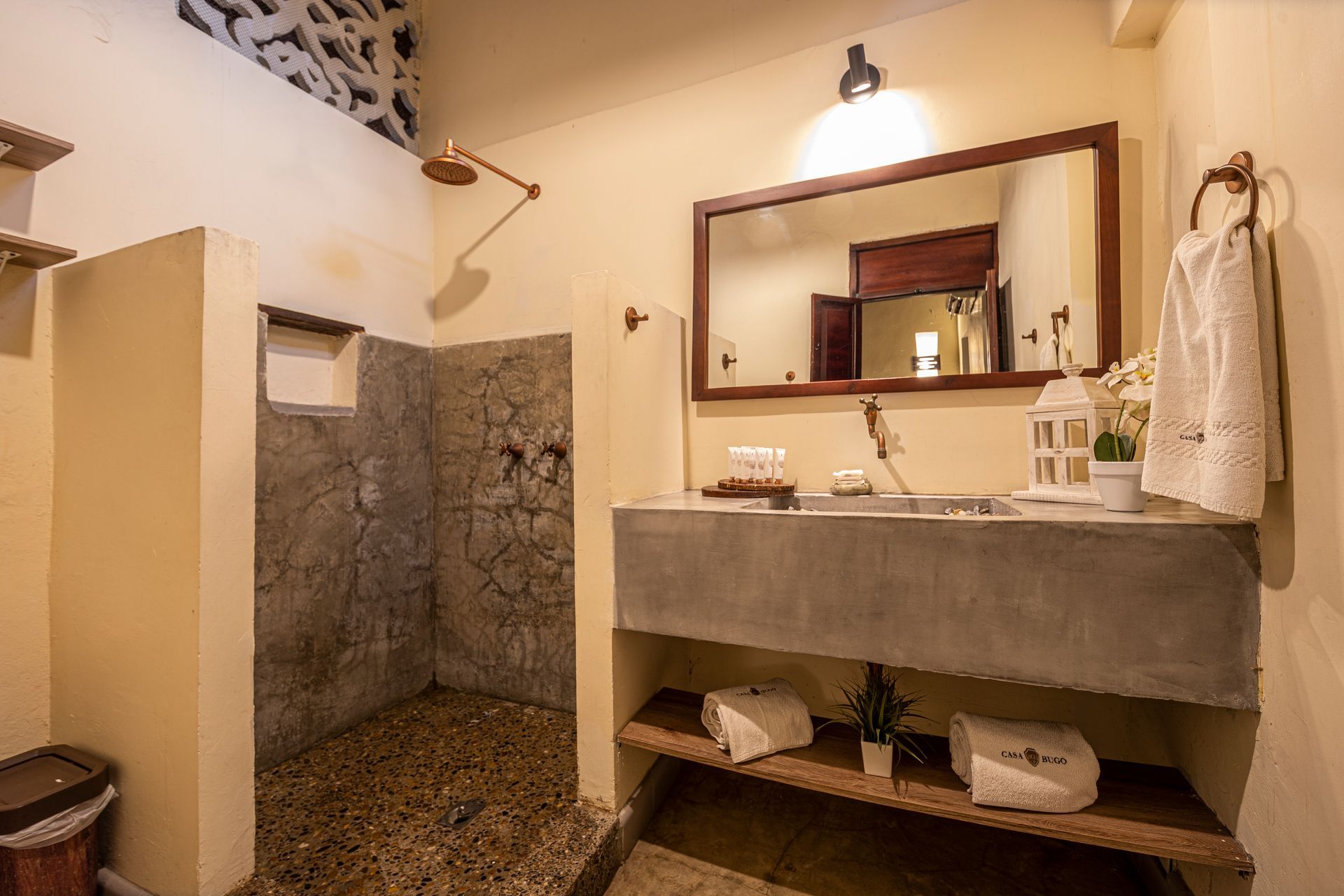 A bathroom with a sink , mirror and walk in shower.