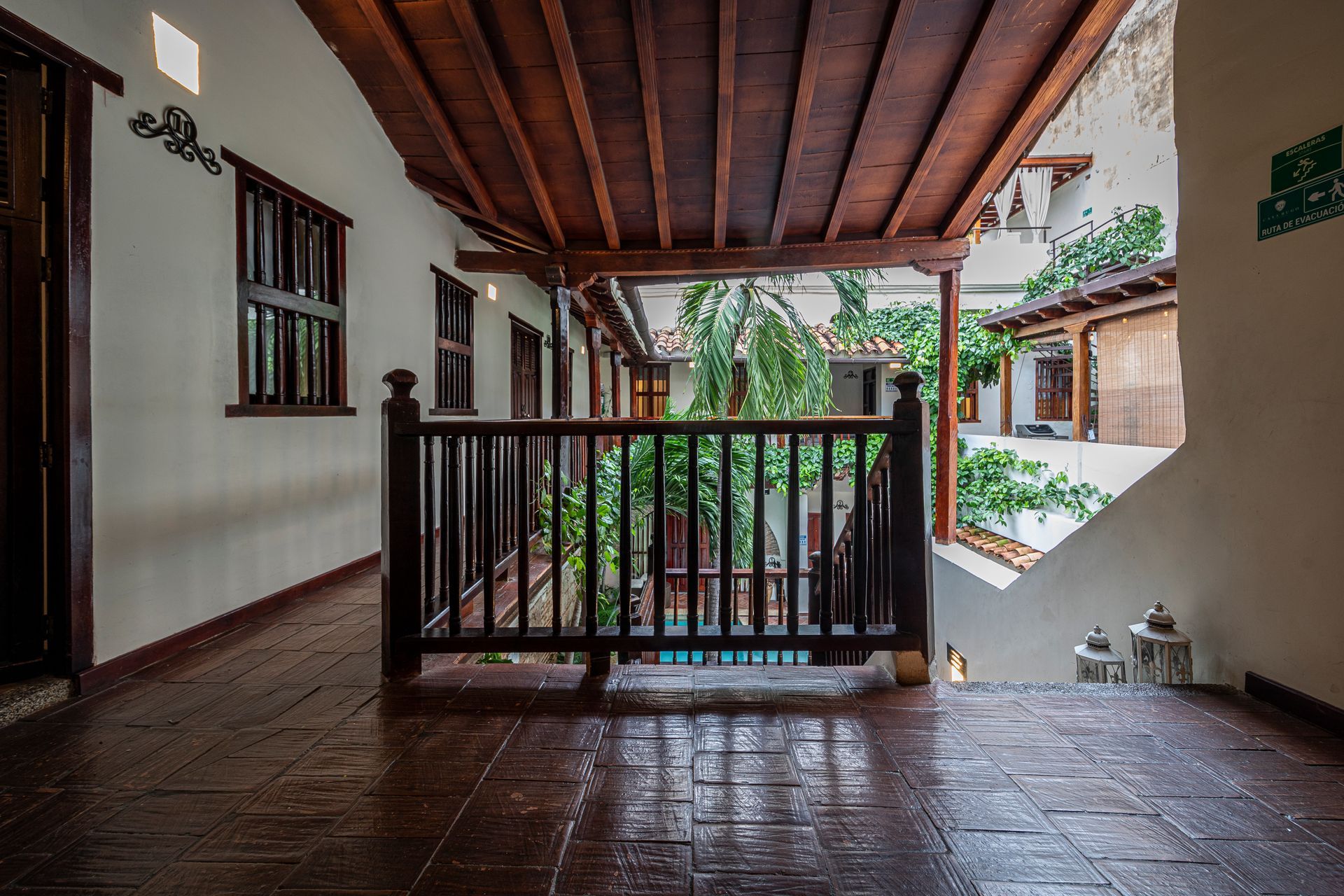An empty hallway with a wooden railing leading to a balcony.