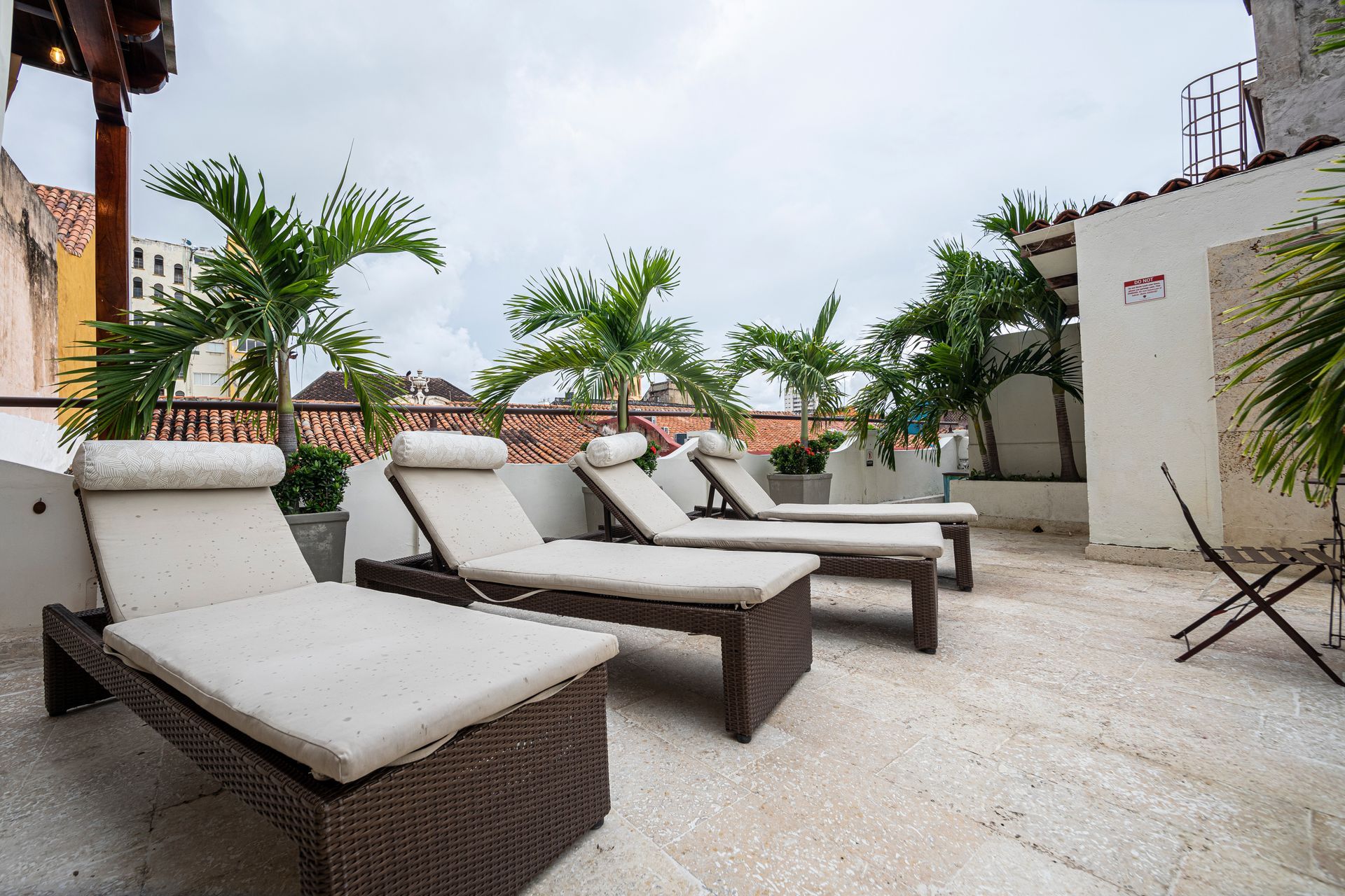 A row of lounge chairs are sitting on a patio.