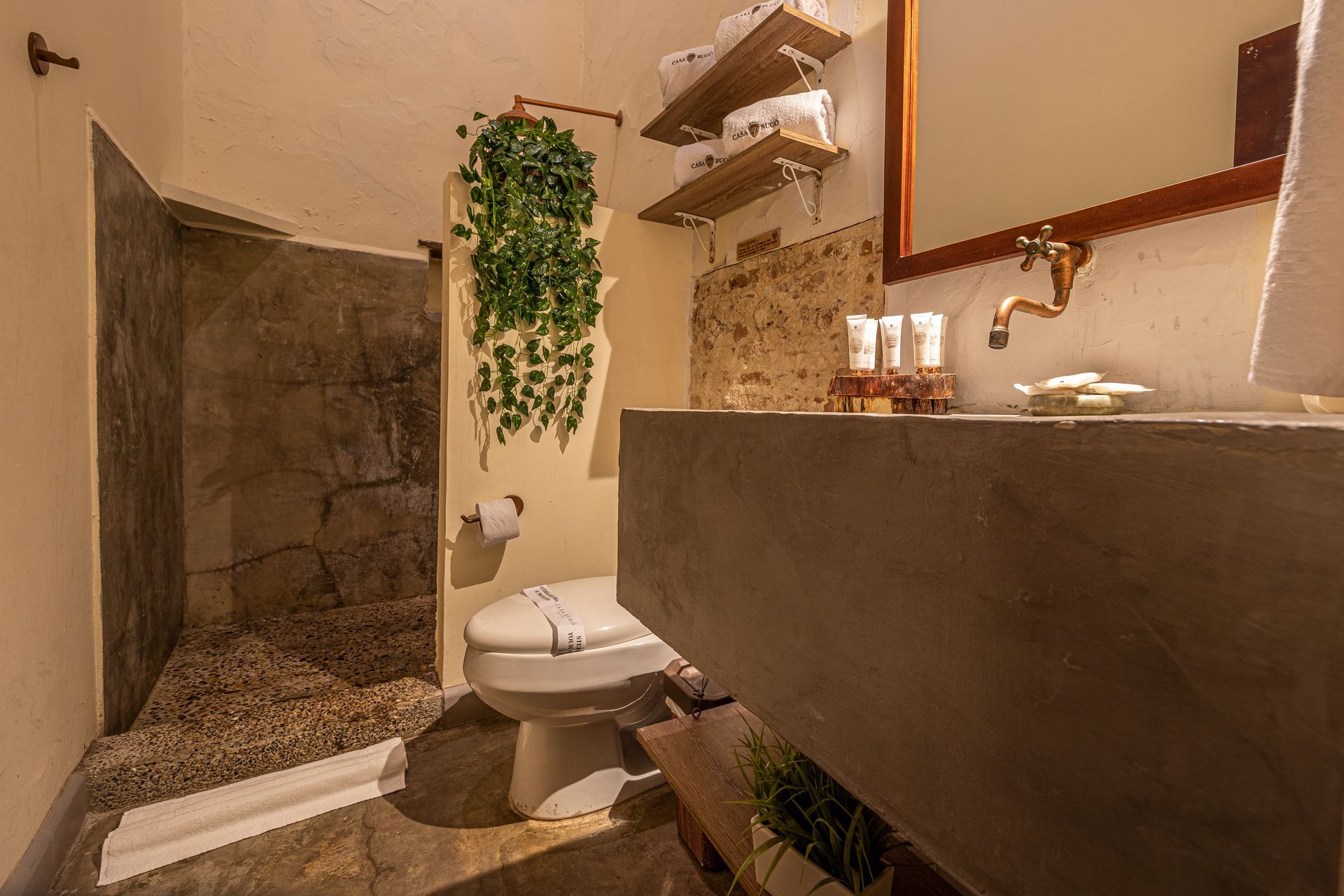 A bathroom with a toilet , sink , mirror and shower.