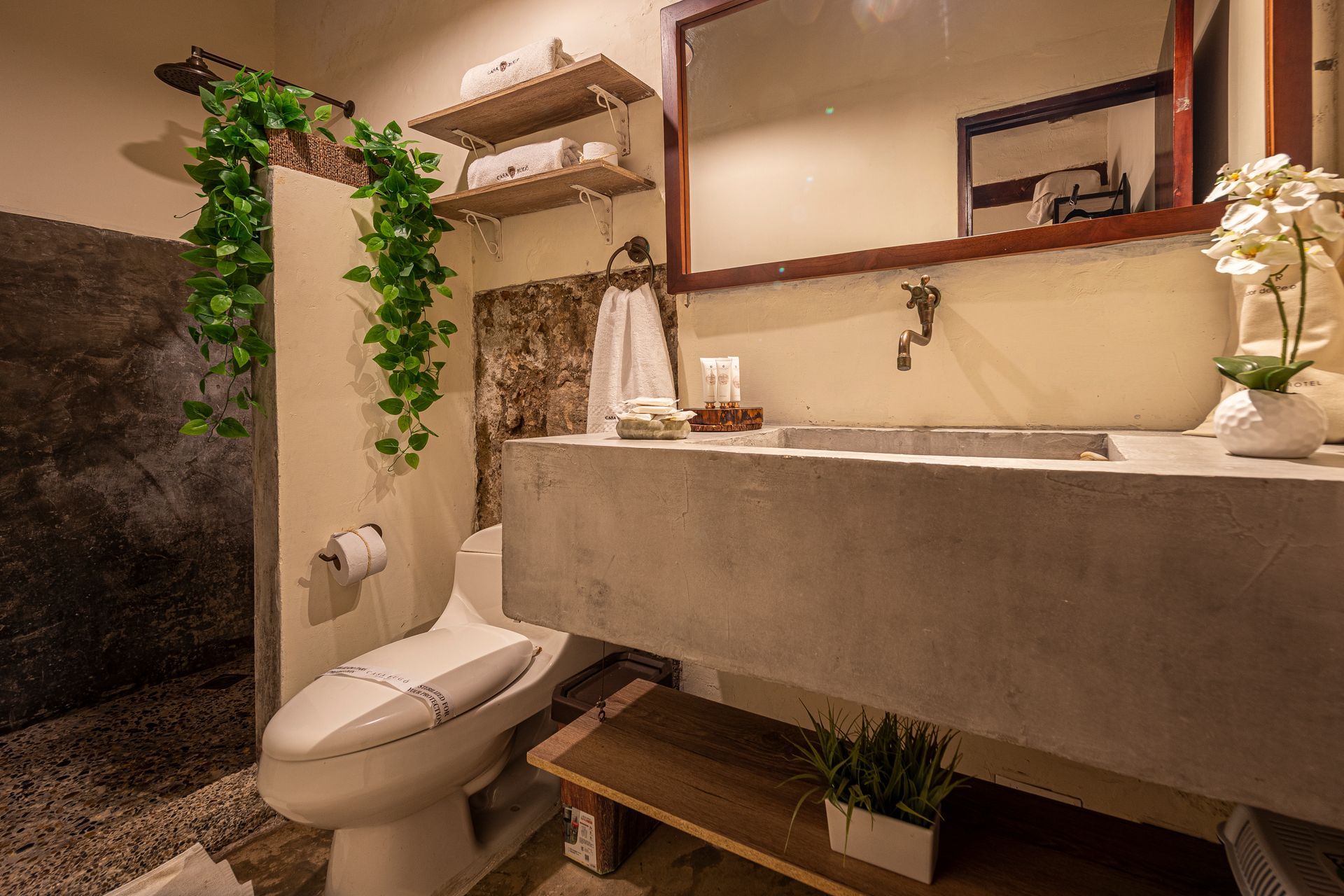 A bathroom with a toilet , sink and mirror.