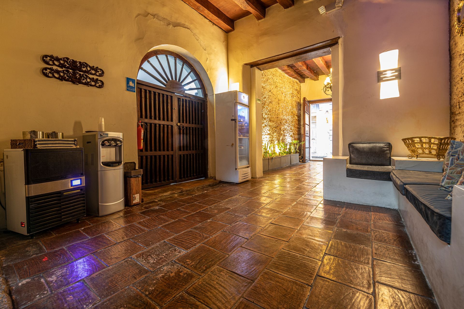 A large room with a tiled floor and a refrigerator.